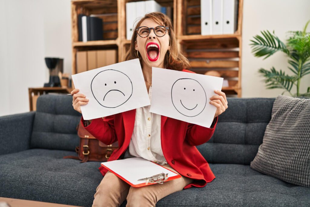 trabalhando na Mulher com depressão segurando papel de emoção triste e feliz com raiva e raiva gritando frustrado e furioso, gritando com raiva olhando para cima. Foto; krakenimages.com/freepik
