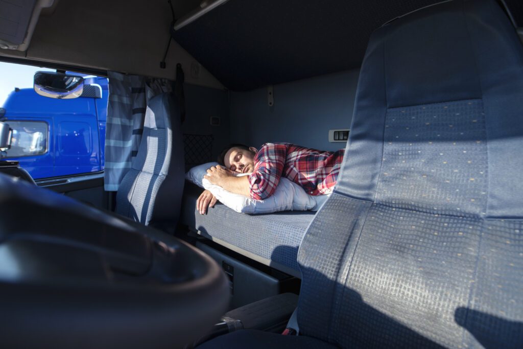 Motorista de caminhão dormindo na cabine. Descanso, Ponto de Parada, Folga, Cansaço Foto: aleksandarlittlewolf/Freepik